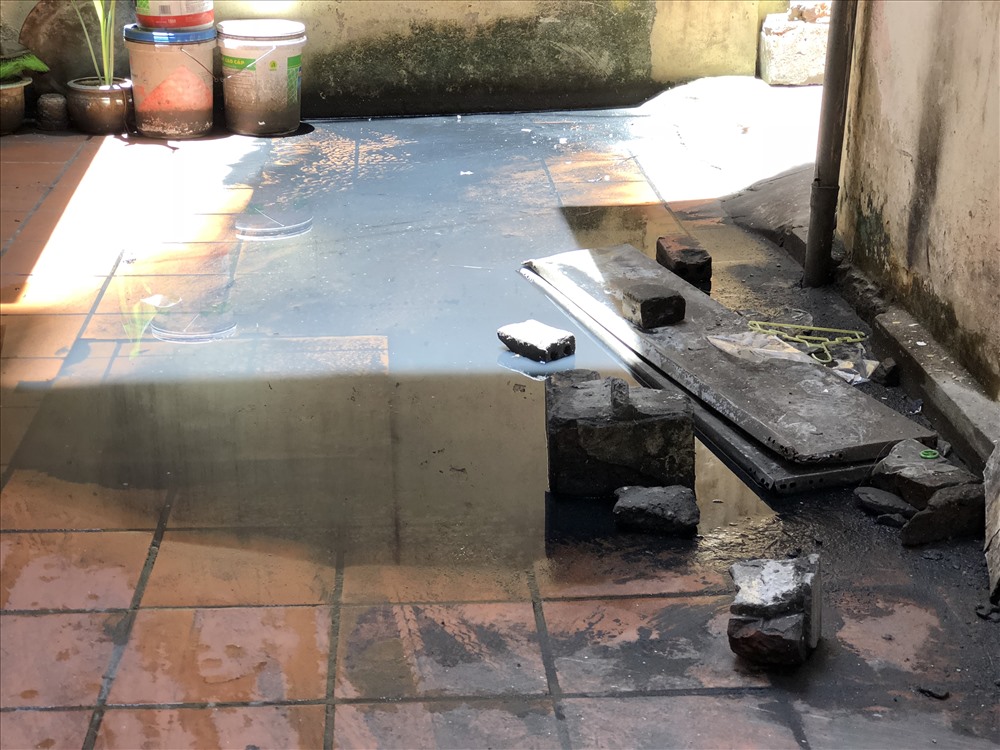 Người dân dùng mọi cách để có thể đi qua vũng nước bể phốt. Nhiều trẻ con, người gia đã bị trượt chân ngã ở đây. Ảnh: Hoàng Tùng