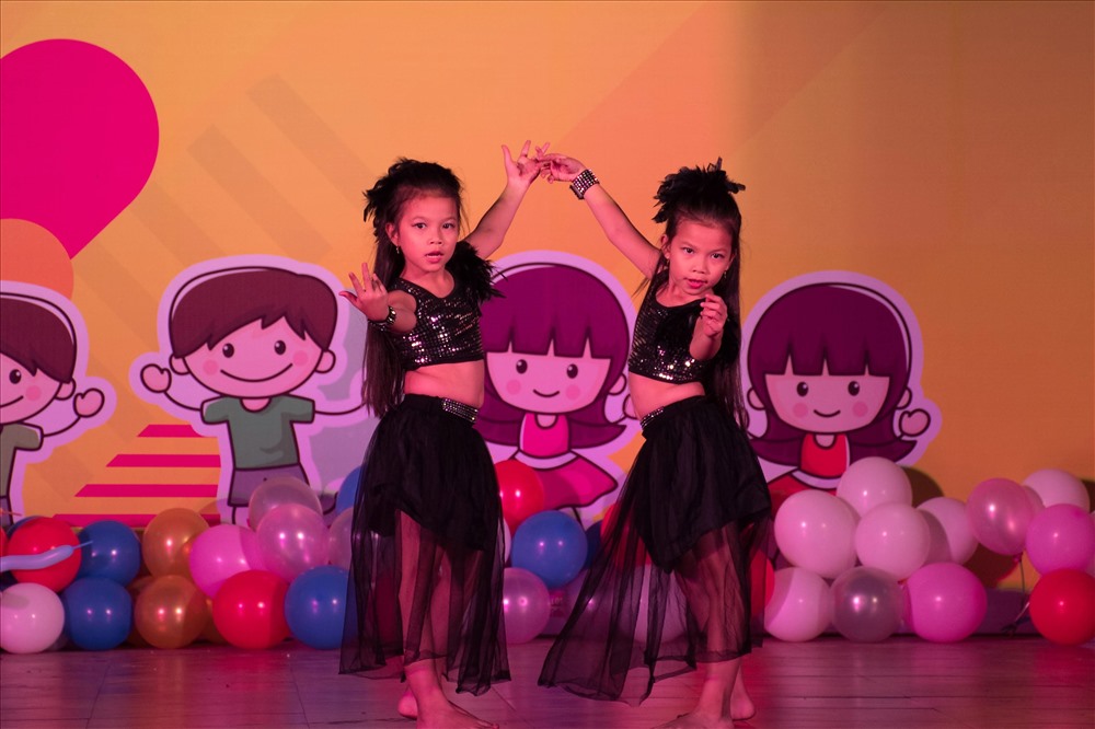 Một cặp song sinh đang trình diễn năng khiếu ca hát trên sân khấu. ảnh: T.S