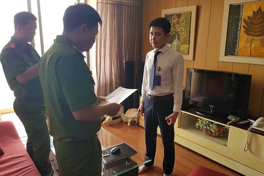 Cảnh sát tống đạt quyết định tố tụng với người liên quan vụ án - Ảnh: Công an cung cấp