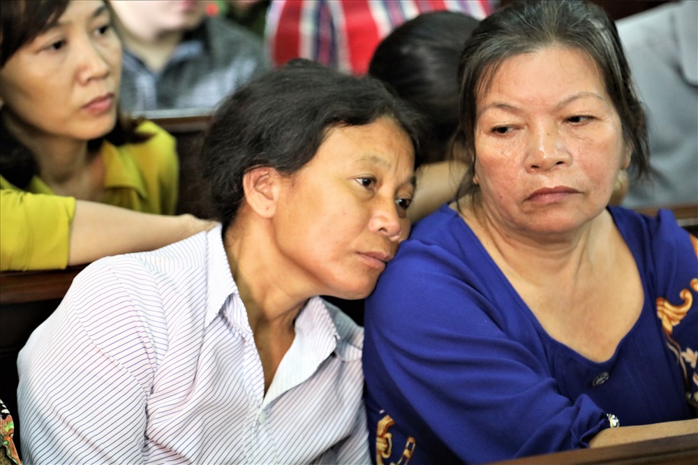 Nghe đến đó, những tiếng khóc rưng rức lại vang lên dưới hàng ghế dành cho gia đình bị hại. Hai người phụ nữ cao tuổi gục đầu vào nhau, trên khóe mắt họ lại rỉ ra những giọt nước mắt. Ảnh: Trường Sơn