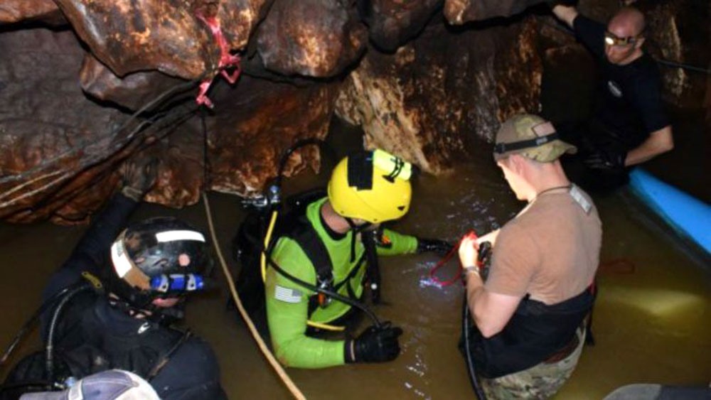 Các thành viên đội cứu hộ bước vào hang động - nơi đội bóng Lợn Hoang mắc kẹt. Ảnh: AP.