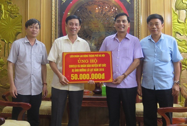 Phó Chủ tịch LĐLĐ TP. Hà Nội Lê Đình Hùng trao cho lãnh đạo huyện Mỹ Đức 50 triệu đồng của LĐLĐ TP. Hà nội hỗ trợ CNVCLĐ và nhân dân huyện Mỹ Đức bị thiệt hại do mưa lũ. Ảnh: LĐLĐ TP. Hà Nội
