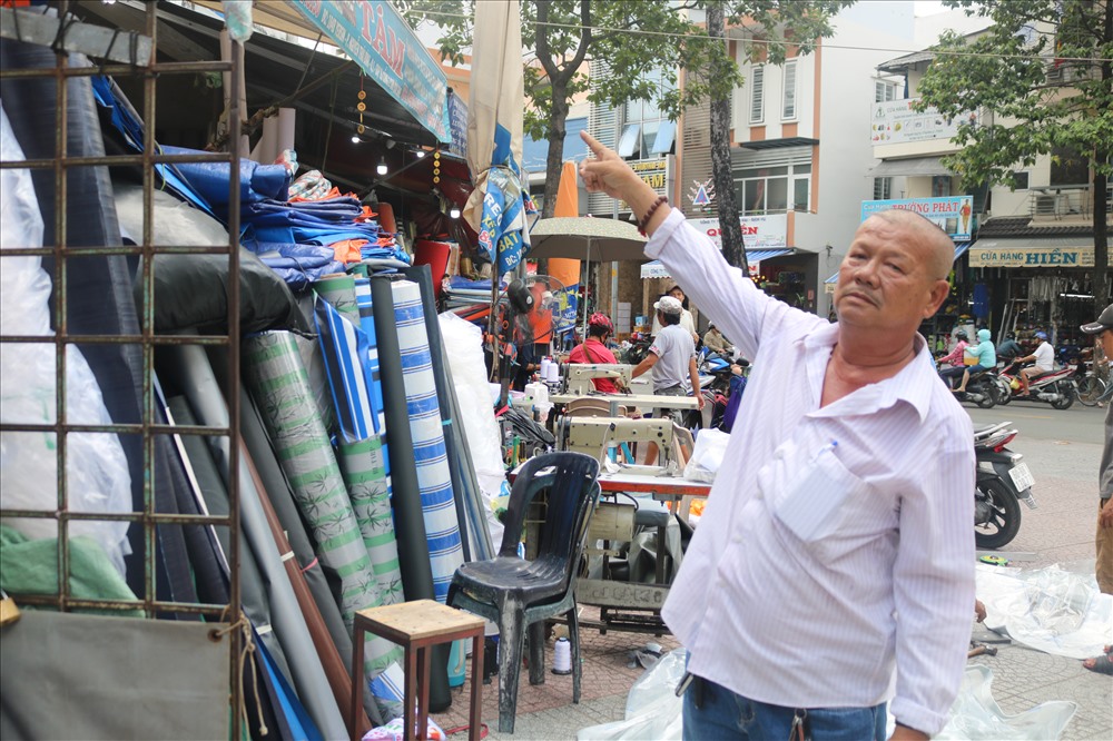 Ông Trương Văn Tám chỉ vào kho hàng của hộ gia đình mình đang tràn ra ngoài đường sau khi đoàn ông Hải rút đi. Ảnh V.H