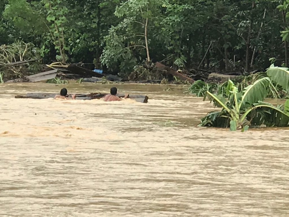 Trước đó, lũ lên quá nhanh, người dân phải bám vào các thanh gỗ để bơi vào bờ. Ảnh Đình Văn