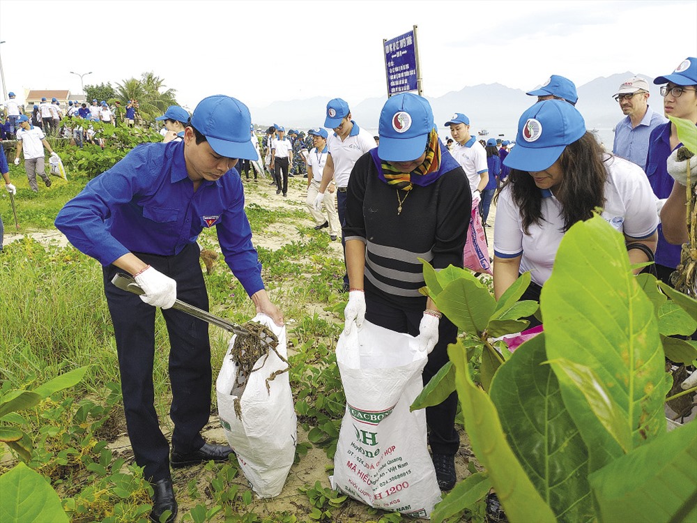 Ô nhiễm môi trường đang đe dọa đến toàn cầu trong đó có Việt Nam. Hình ảnh người dân Đà Nẵng cùng du khách nhặt rác làm sạch bờ biển.