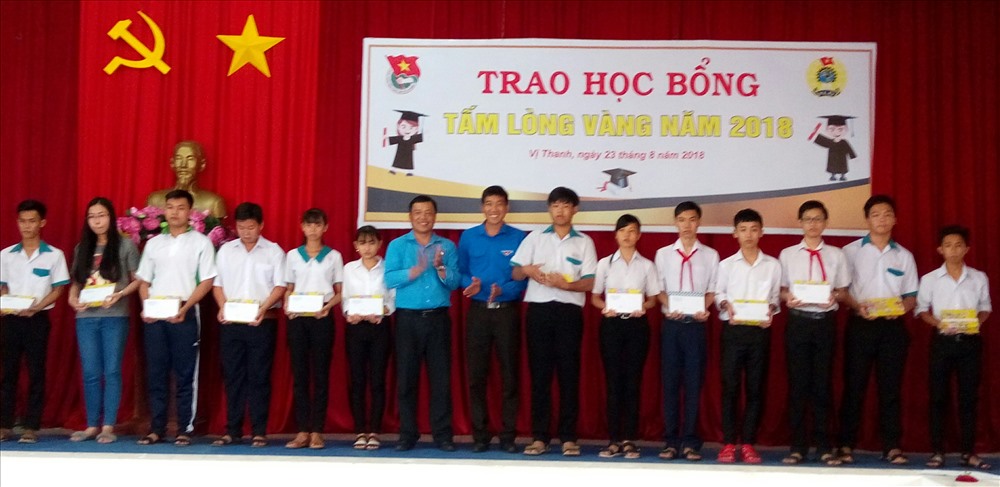 Ông Phan Văn Nhớ - Chủ tịch LĐLĐ Thành phố Vị Thanh trao quà cho các em học sinh