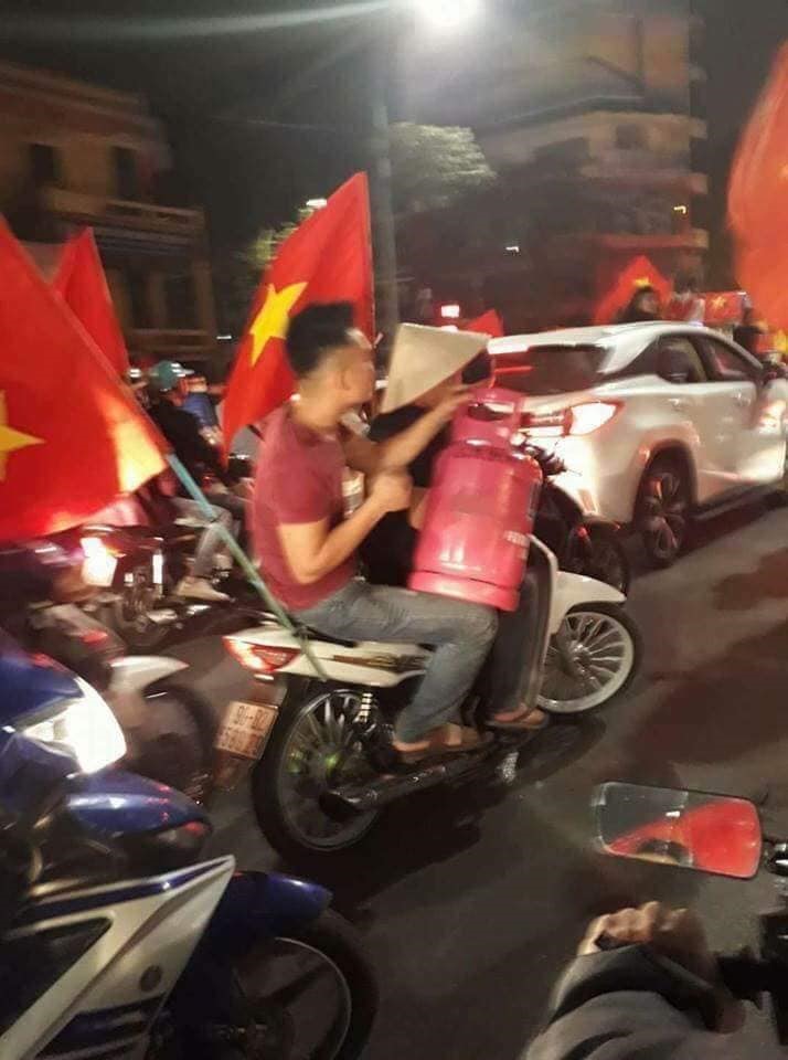 Vì quá khích nên thanh niên này còn mang cả bình gas ra đường ăn mừng. Ảnh: Nhật Tân.