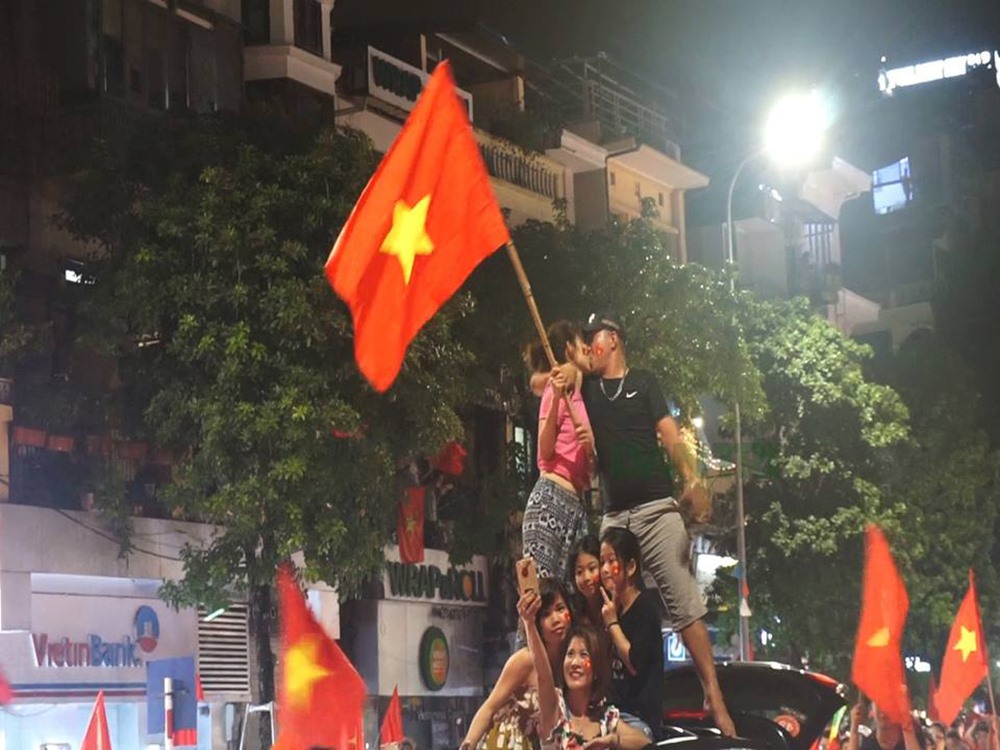 Một cặp đôi trao nhau nụ hôn vào khoảnh khắc lịch sử của U23 Việt Nam. Ảnh: Nguyễn Dương.