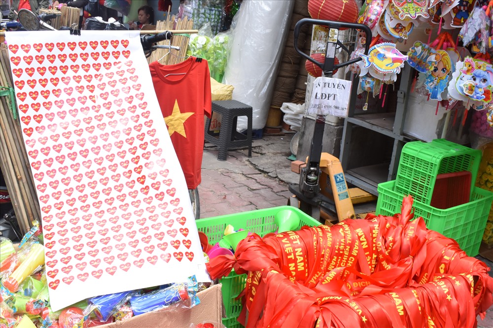 Dù đang là mặt hàng “hot” nhưng các chủ cửa hàng ở đây đều không tăng giá tiền, các mặt hàng vẫn được giữ nguyên giá như miếng dán 2.000 đồng/cái, áo 50.000 đồng/cái, cờ 30.000/cái.
