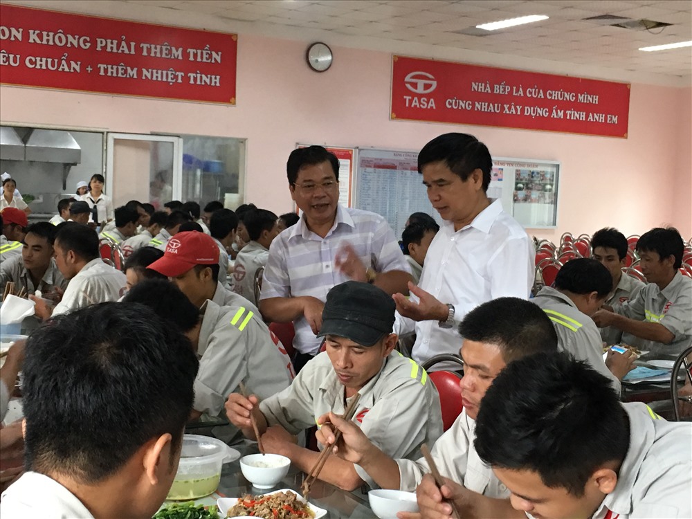Các ông Quách Tấn Công - Trưởng ban Tuyên giáo LĐLĐ tỉnh Phú Thọ (áo kẻ ngang), Phạm Hữu Vũ - Chủ tịch Công đoàn Cty (áo trắng) chia vui với công nhân Cty trong bữa ăn ca liên hoan.