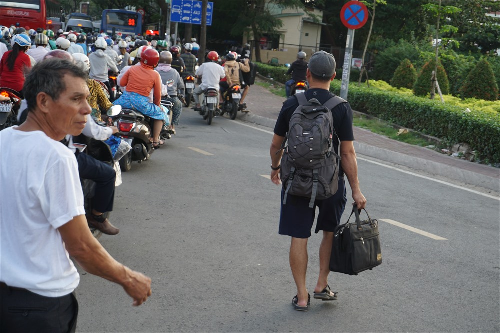 Kẹt xe sợ trễ giờ, hành khách xuống taxi đi bộ vào bến xe Miền Đông.