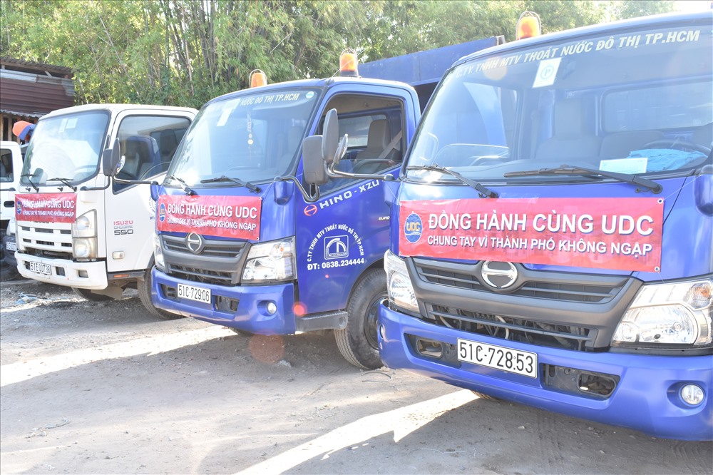 Những chiếc xe chở bùn được gắn băng rôn nhằm nâng cao ý thức người dân trong việc xả rác nơi miệng cống