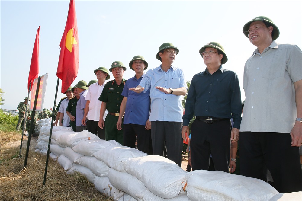 Bí thư Tỉnh ủy Nguyễn Văn Đọc báo cáo với Phó Thủ tướng Trịnh Đình Dũng phương án bảo vệ, gia cố tuyến đê Hà Nam (TX. Quảng Yên). Ảnh: BQN
