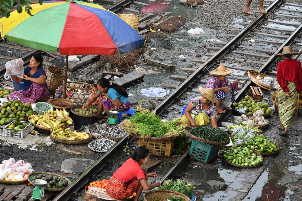 Sau cơn mưa, đất lầy lội, ngồi bán trên đường sắt chả sung sướng gì.
Nhiều chị ôm con theo đi bán hàng.