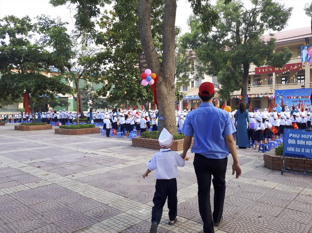 Một số học sinh đến muộn được bảo vệ đưa vào trường. Ảnh Trần Vương