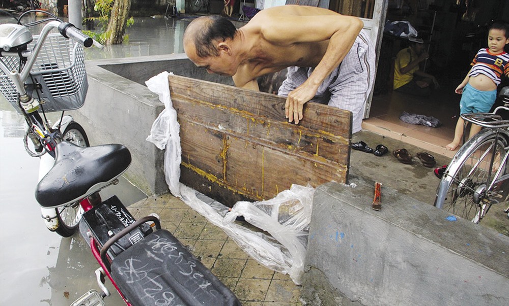 Anh Nguyễn Thành Phú (44 tuổi, nhà 40/B3, tổ 2, ấp 3, KDC An Phú) cho biết mặc dù nâng cao nền nhà nhưng ở phía trước vẫn phải xây tường cao thêm gần cả mét và dùng tấm ván để ngăn mỗi khi trời mưa.