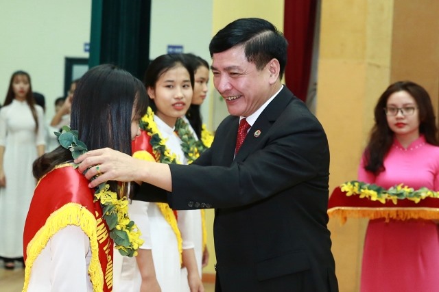 Chủ tịch Tổng LĐLĐVN Bùi Văn Cường trao học bổng và vòng nguyệt quế cho các thủ khoa đầu vào của Trường Đại học Công đoàn. Ảnh: Hải Nguyễn
