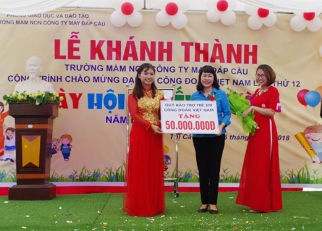 Bà Trịnh Thanh Hằng - Ủy viên Đoàn Chủ tịch, Trưởng ban Nữ công Tổng LĐLĐVN, Giám đốc Quỹ Bảo trợ trẻ em CĐVN (giữa) tặng Trường Mầm non Cty May Đáp Cầu 50 triệu đồng. Ảnh: CĐ Dệt May VN