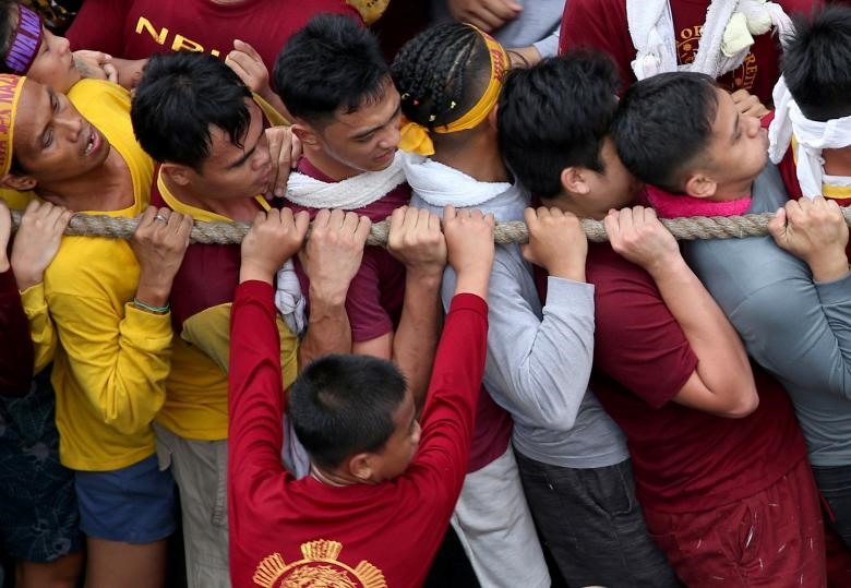 Đám đông thanh niên tham gia kéo dây thừng của chiếc xe ngựa chở tượng Black Nazarene. Ảnh: Reuters.