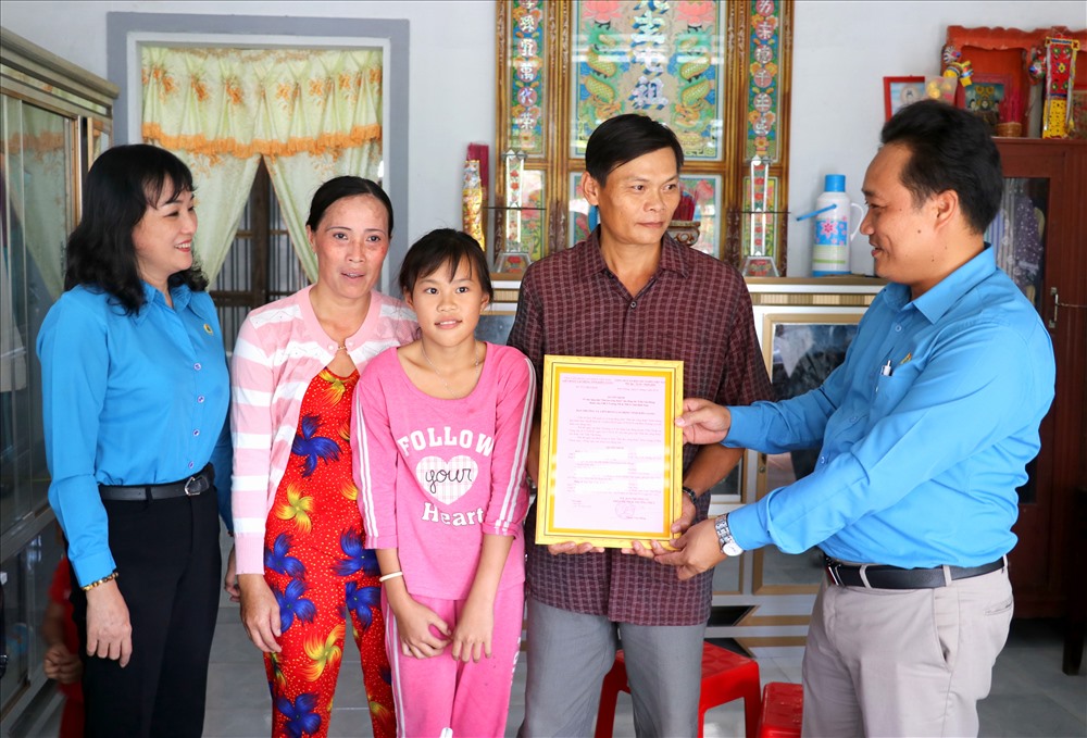 Phó Chủ tịch LĐLĐ Kiên Giang Phạm Văn Đằng trao quyết định MÂCĐ cho đoàn viên Trần Văn Hùng cùng gia đình. Ảnh: LT