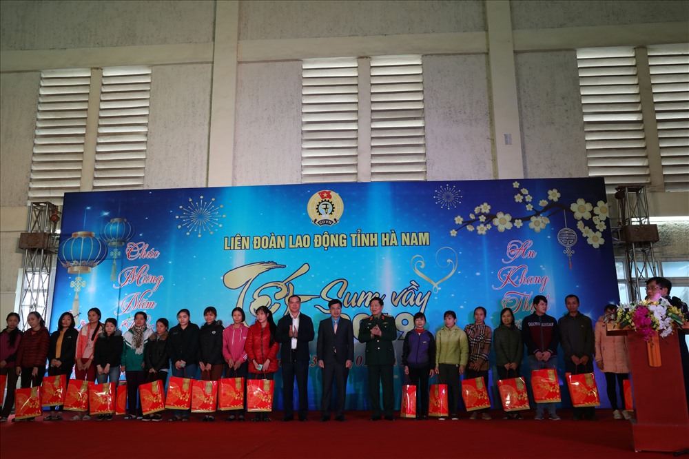 Bộ trưởng Bộ Quốc Phòng Ngô Xuân Lịch (phải) và Bí thư Tỉnh uỷ Hà Nam Nguyễn Đình Khang (trái) và Chủ tịch LĐLĐ tỉnh Hà Nam Trịnh Văn Bừng (giữa) tặng quà CNLĐ khó khăn tại Hà Nam.