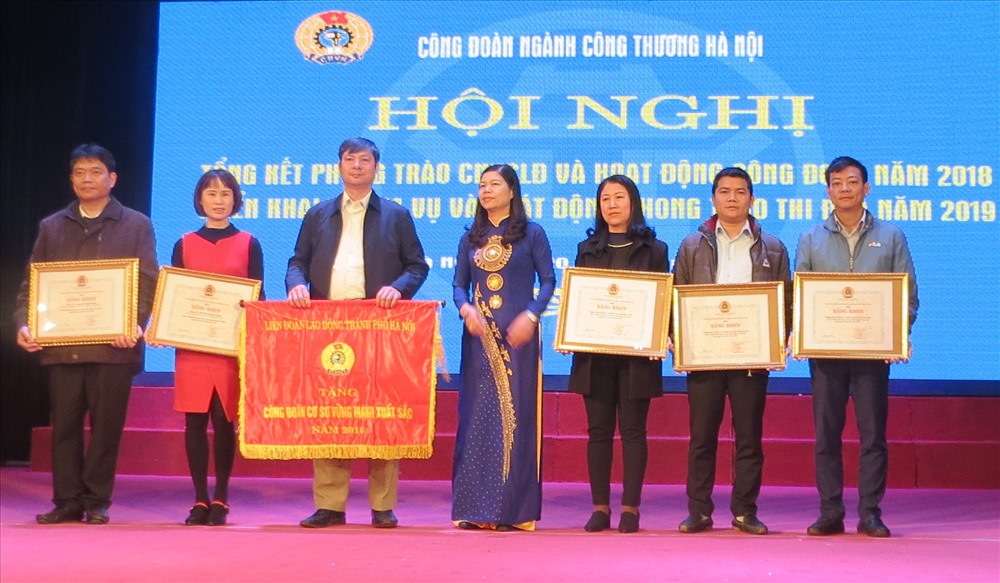 Bà Đặng Thị Phương Hoa - Phó Chủ tịch Thường trực LĐLĐ TP. Hà Nội trao Cờ, Bằng khen của LĐLĐ TP. Hà Nội cho các tập thể và cá nhân có thành tích xuất sắc. Ảnh: Xuân Trường