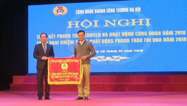 ông Trần Quang Huy - Ủy viên Đoàn Chủ tịch Tổng LĐLĐVN, Chủ tịch CĐ Công thương VN trao Cờ thi đua xuất sắc của Tổng LĐLĐVN ( bên trái) cho CĐ Cty TNHH Phụ tùng ô tô xe máy Goshi Thăng Long. Ảnh: Xuân Trường