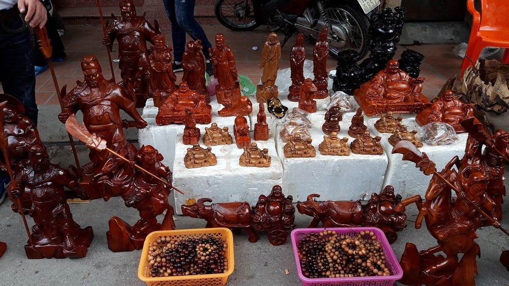 Tượng phật và tượng Quan Công làm bằng gỗ có giá thành hợp lý được bán tại chợ.