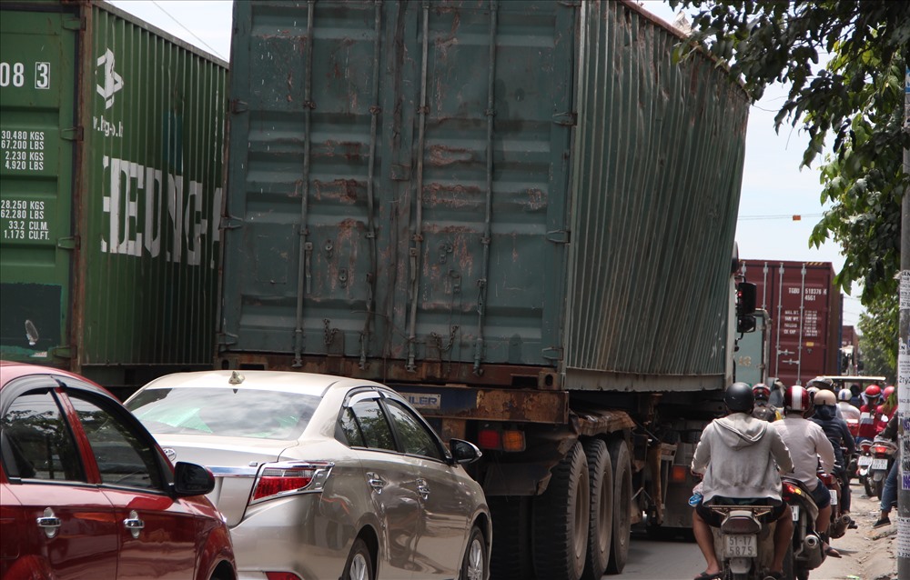 Bị container lấn hết đường các phương tiện phải le lên vỉa hè di chuyển.