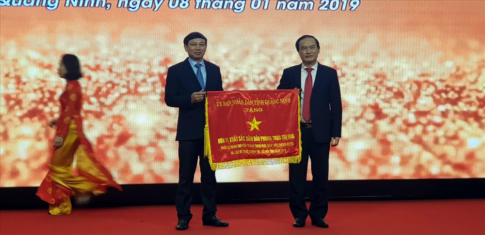Phó Bí thư Thường trực Tỉnh ủy Quảng Ninh, ông Nguyễn Xuân Ký trao tặng cờ đơn vị dẫn đầu khối thi đua mặt trận và các tổ chức đoàn thể cho LĐLĐ Quảng Ninh. Ảnh: T.N.D