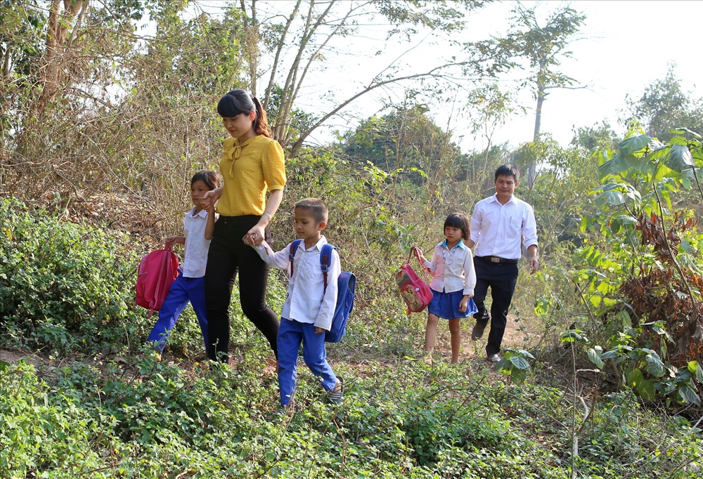 Dù đã vận động, nhưng không ít học sinh vẫn “quên” đường đến lớp nên cô giáo Đoàn Thị Ánh Nguyệt - giáo viên Trường Tiểu học Thanh phải đến tận nhà đưa học sinh đi học. Ảnh: Hưng Thơ.