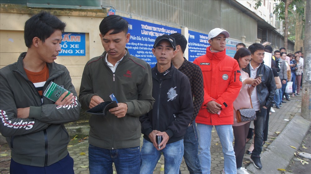 Phía trong và ngoài mọi người đều xếp hàng chờ đến lượt mình dưới sự giám sát của lực lượng công an