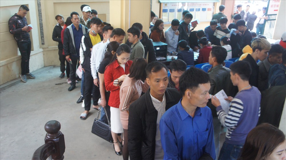 Phía trong và ngoài mọi người đều xếp hàng chờ đến lượt mình dưới sự giám sát của lực lượng công an