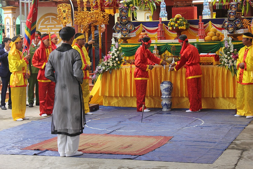 Đổ rượu vào bình để làm lễ.