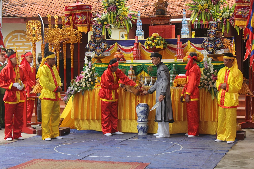 Chủ lễ cắt tiết gà pha rượu ăn thề.
