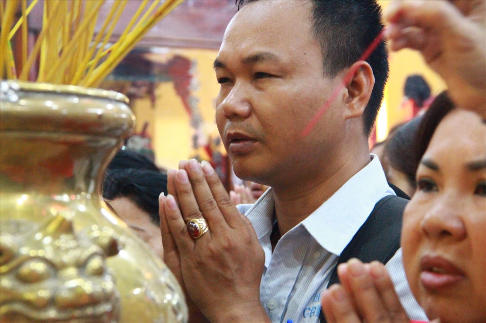 Nam thanh niên bị ép sát vào lư hương đứng khấn vái.