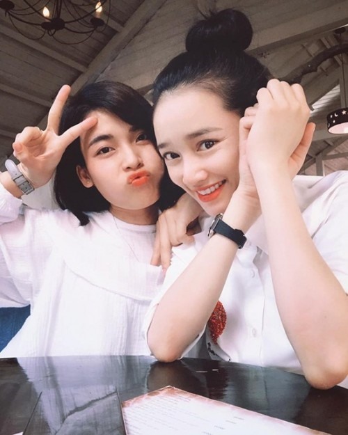Bà xã Trường Giang búi tóc cao, diện áo sơ mi trắng giản dị.