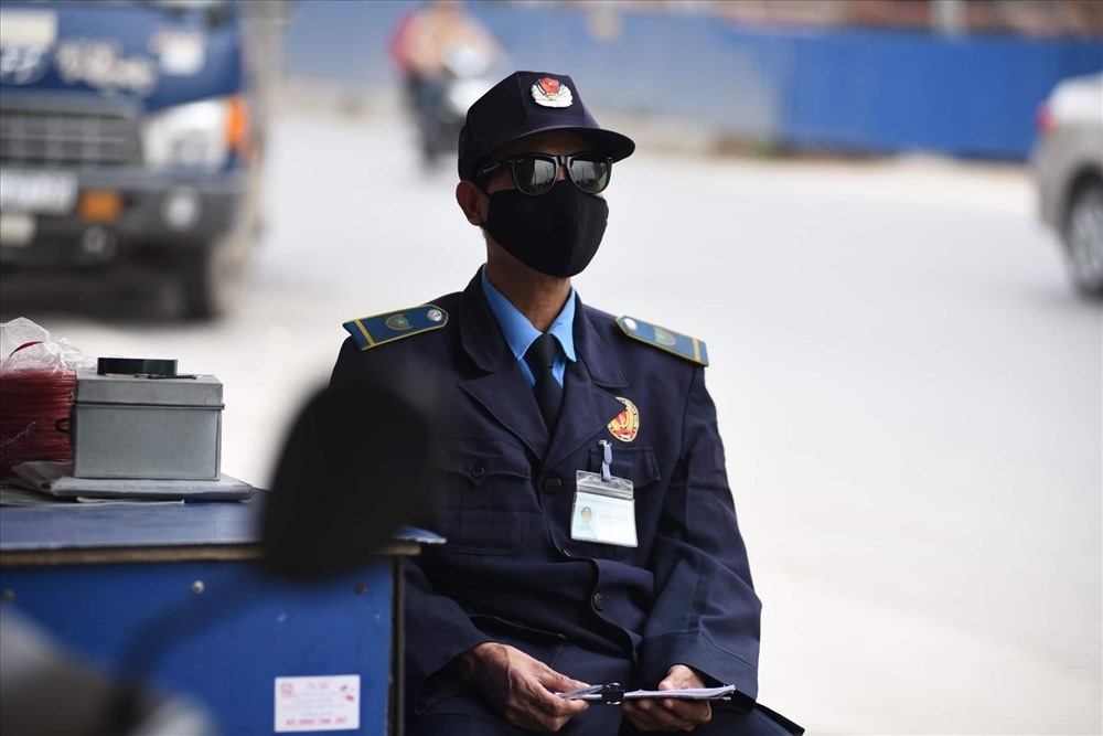 Những người bảo vệ phải đeo khẩu trang 24/24 trước tình trạng bụi từ công trường bay ra. Ảnh: Duy Hiệu