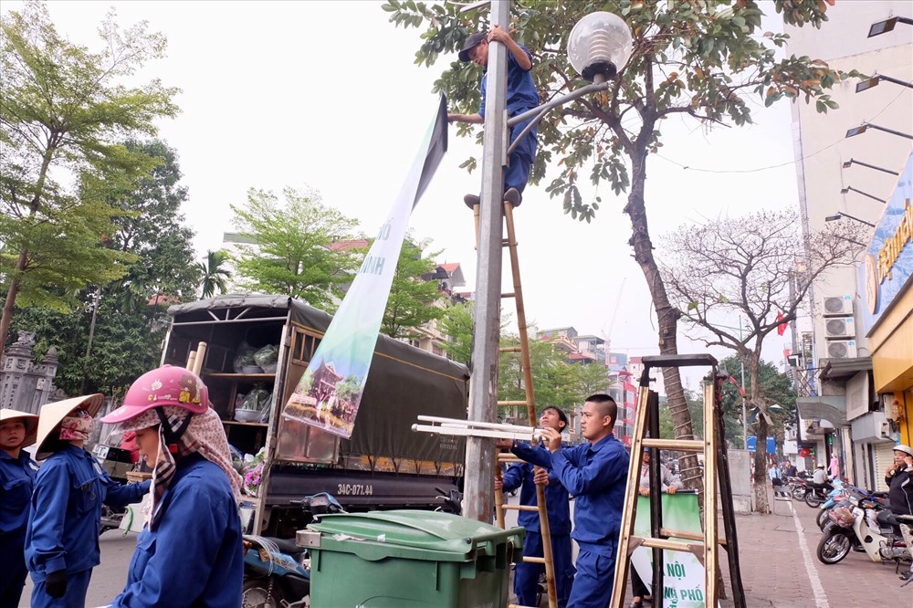 Trên đường Giảng Võ, công nhân đang trồng thêm cây xanh ở giải phân cách.