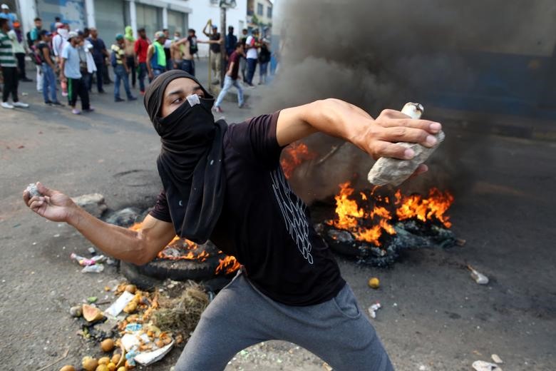 Để mở đường cho 2 chiếc xe tiến vào lãnh thổ Venezuela, các đối tượng quá khích đã ném bom xăng tự chế về phía lực lượng an ninh Venezuela. Ảnh: Reuters.