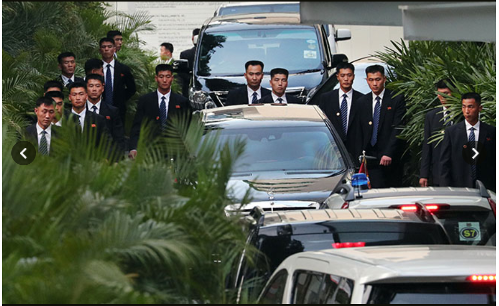 Dàn vệ sĩ xung quanh chiếc xe chở nhà lãnh đạo Triều Tiên Kim Jong-un tại Singapore khi ông tới đây dự hội nghị thượng đỉnh với Tổng thống Donald Trump hồi tháng 6.2018. Ảnh: Asahi.
