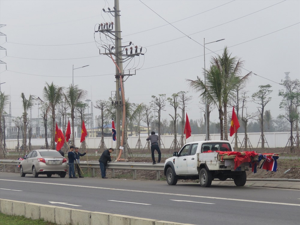 Công nhân đang treo cờ Việt Nam - TRiều Tiên trưa ngày 26.2 tại khu vực trước cổng nhà máy ô tô Vinfast