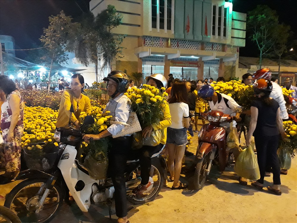 Nhiều người chọn đi mua hoa vào buổi tối để tránh tình trạng chen lấn. Ảnh: H.T