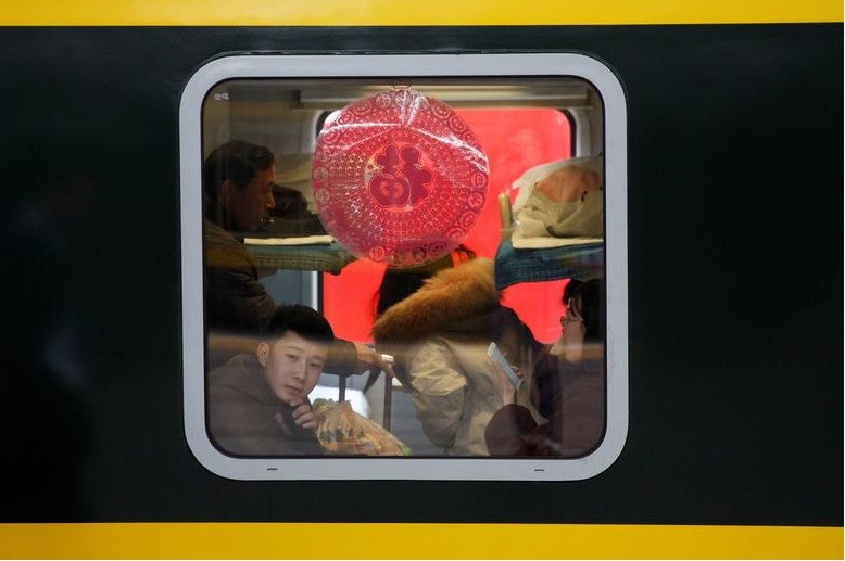 Hành khách ngồi trên chuyến tàu tại ga Bắc Kinh ngày 31.1.