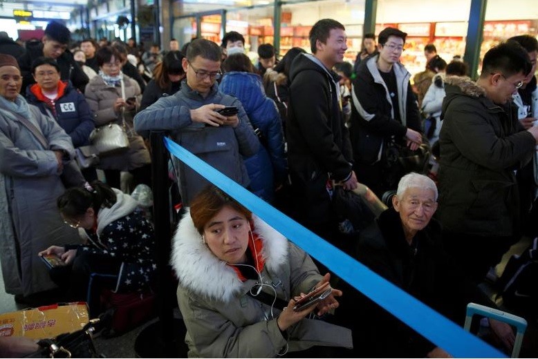 Những hành khách chờ tàu mỏi mệt ở ga Bắc Kinh.