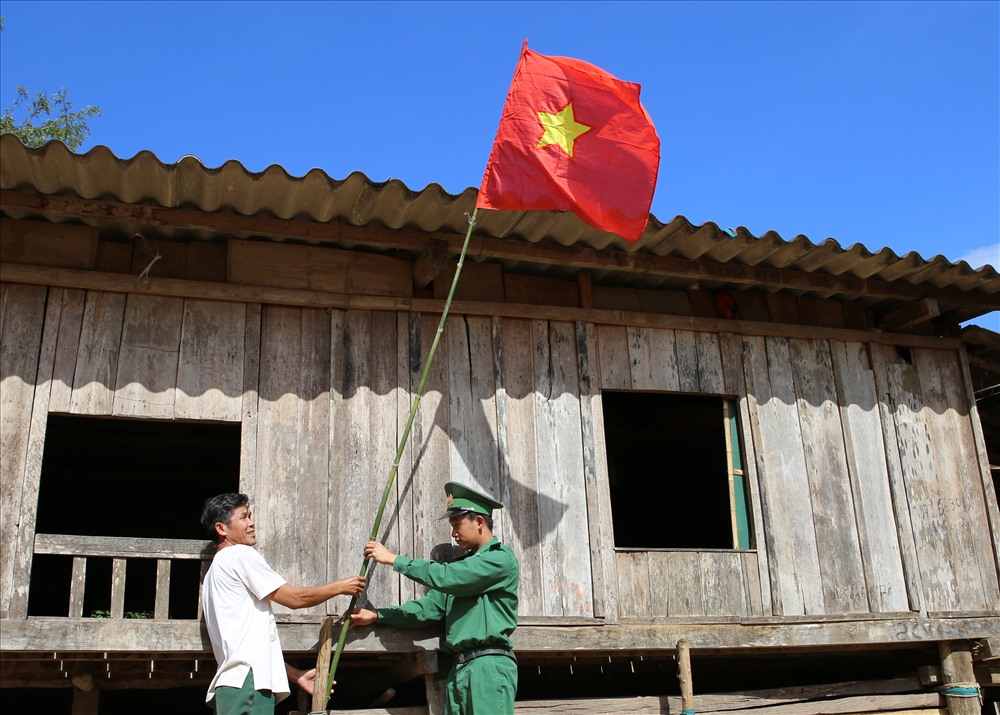 Lá cờ Tổ quốc lần đầu tiên được tung bay ở bản Xâm Cư sau gần 20 năm từ ngày những nóc nhà sàn được dựng lên. Ảnh: Hưng Thơ.