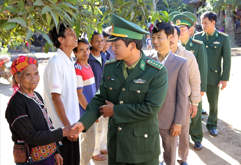 Cán bộ, chiến sĩ Đồn Biên phòng Ba Tầng đến chúc tết bà con ở bản Xâm Cư. Ảnh: Hưng Thơ.
