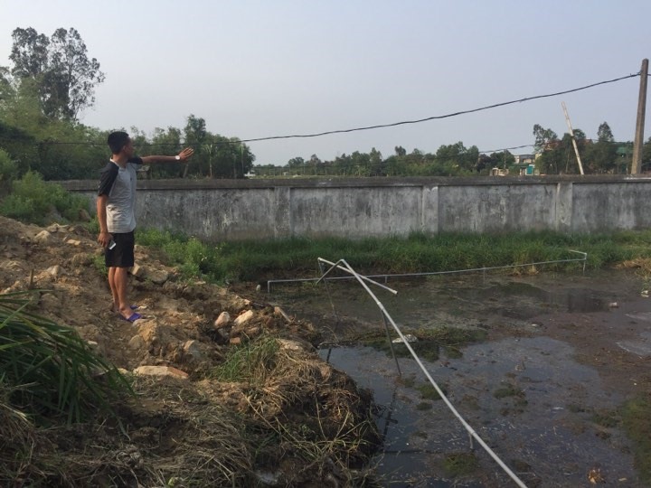 Mảnh đất trống sau lò mổ là nơi tập trung nhiều chất thải bẩn ứ đọng trong nhiều năm, thậm chí tràn cả vào mương nước cạnh nhà người dân. Ảnh: Viễn Chinh.