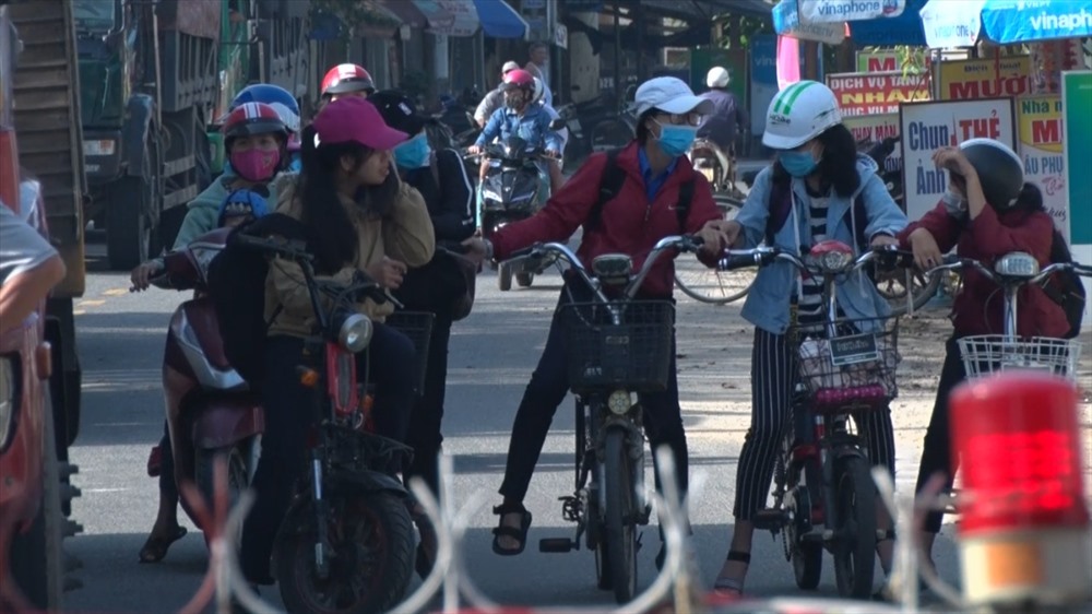 Học sinh đi học và công nhân đi làm vẫn phải đứng đợi vì tàu hỏa chắn ngang đường. Ảnh: Đ.V