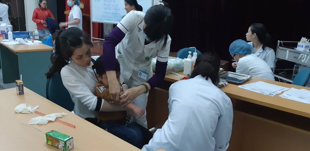 Phụ huynh trong trường đưa con đi xét nghiệm tại bệnh viện.